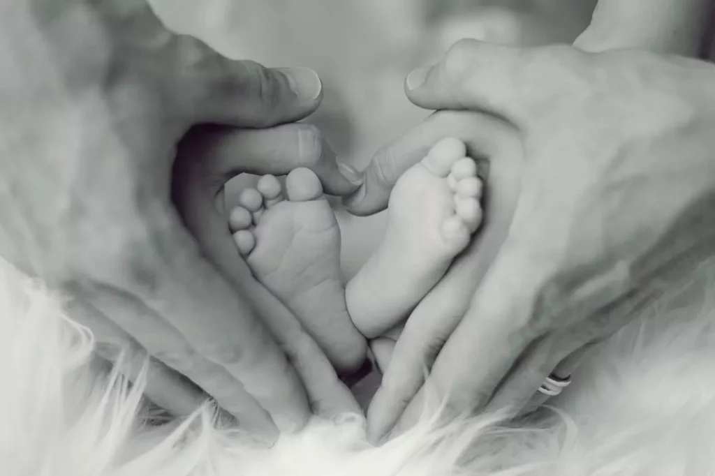 Souvenir de bébé: Mains des parents entourant les pieds de bébé