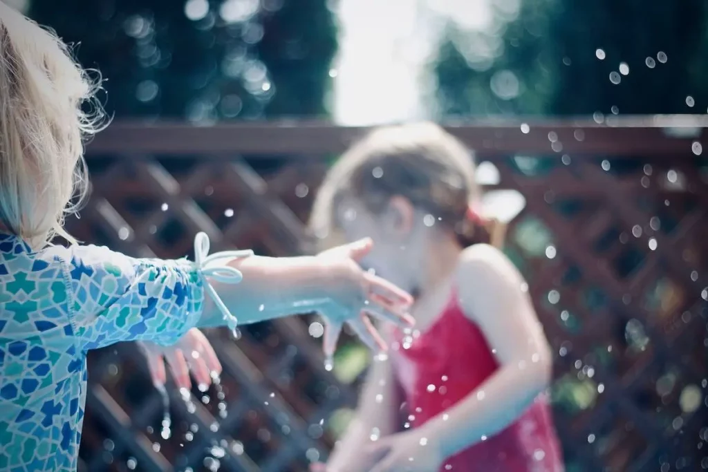 Enfants jouant avec l'eau au soleil