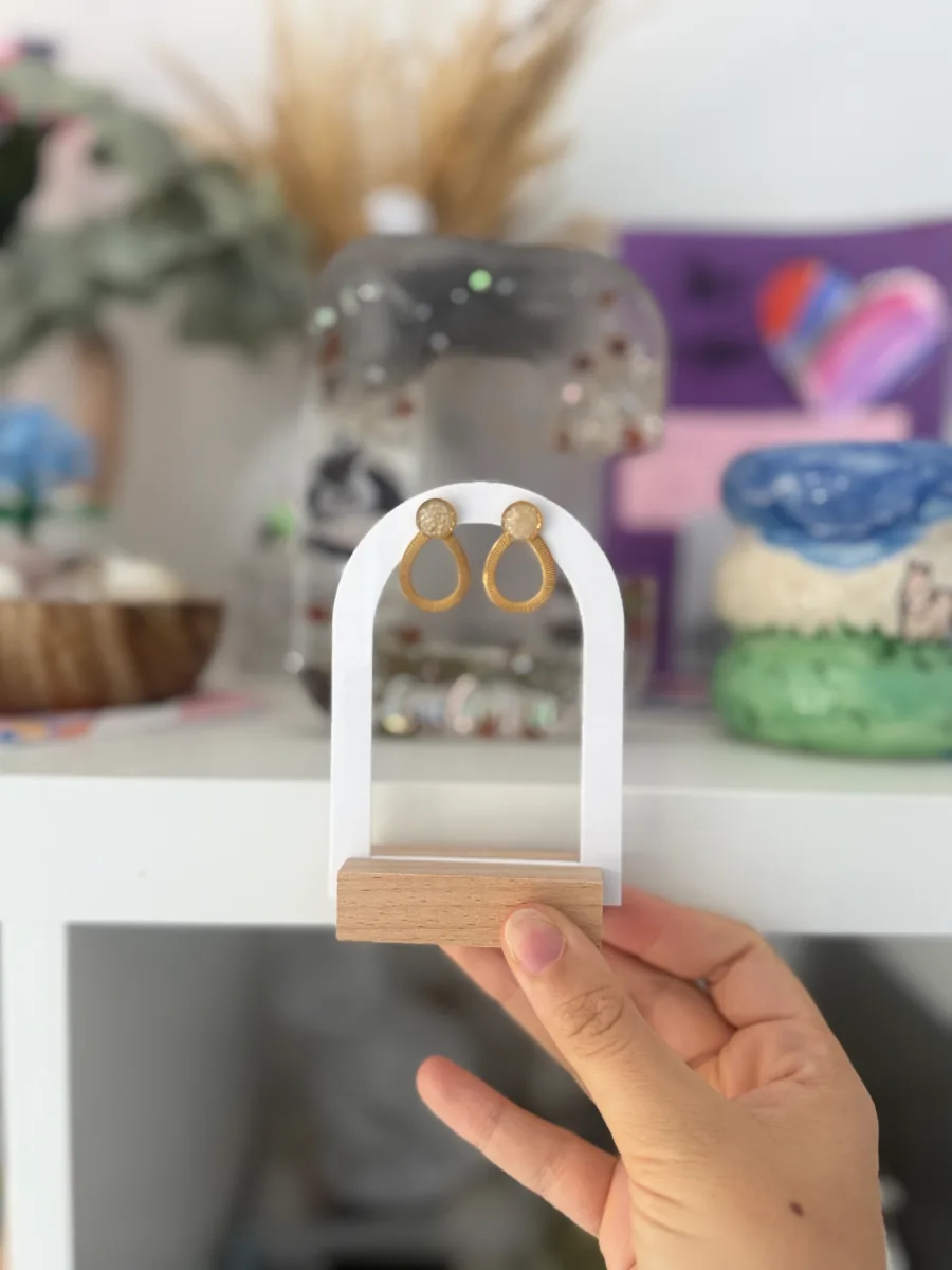 Boucles d'oreilles gouttes au lait maternel sur un présentoir en arche blanc