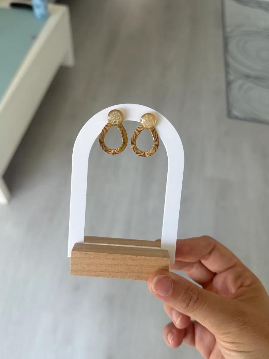 Gouttes dorées au lait maternel accrochées à un présentoir en arche