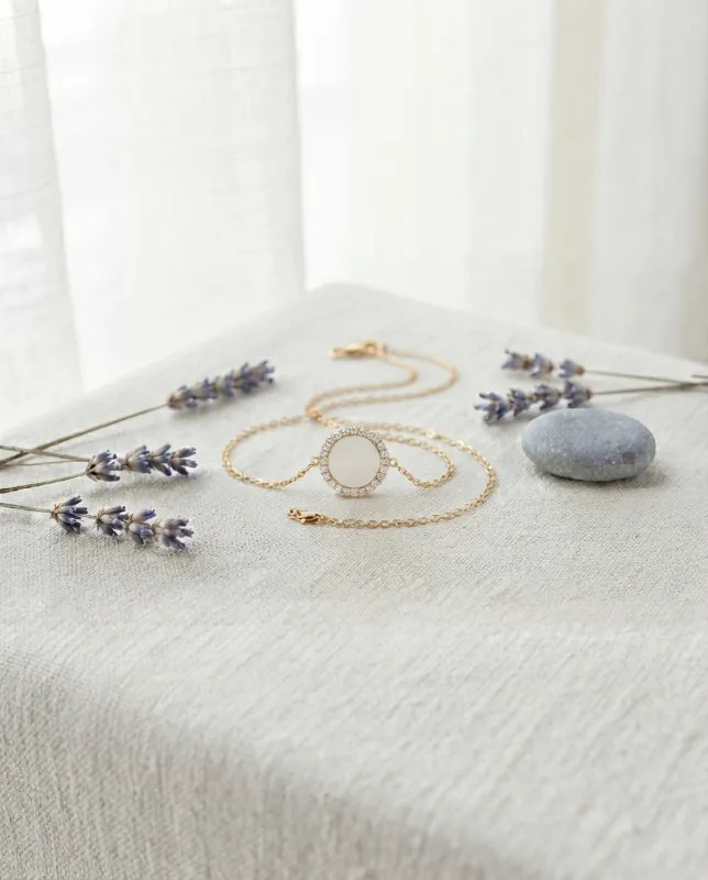 Collier rond au lait maternel sur chaîne dorée, posé avec de la lavande et un galet