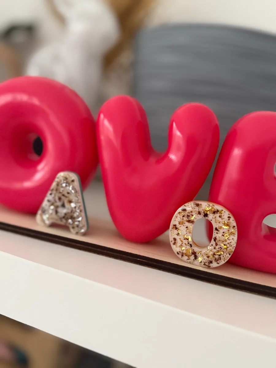 Initiales au cordon ombilical devant de grandes lettres roses