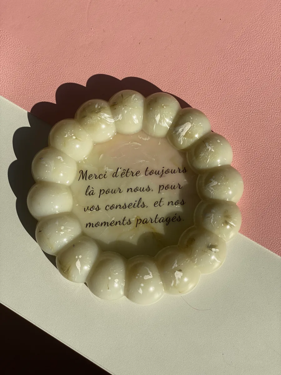 Plateau en résine crème avec un message de remerciement écrit à la main, sur fond rose