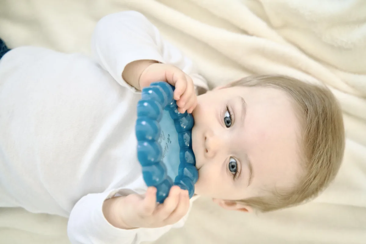 Bébé allongé tenant un plateau en résine bleu personnalisé