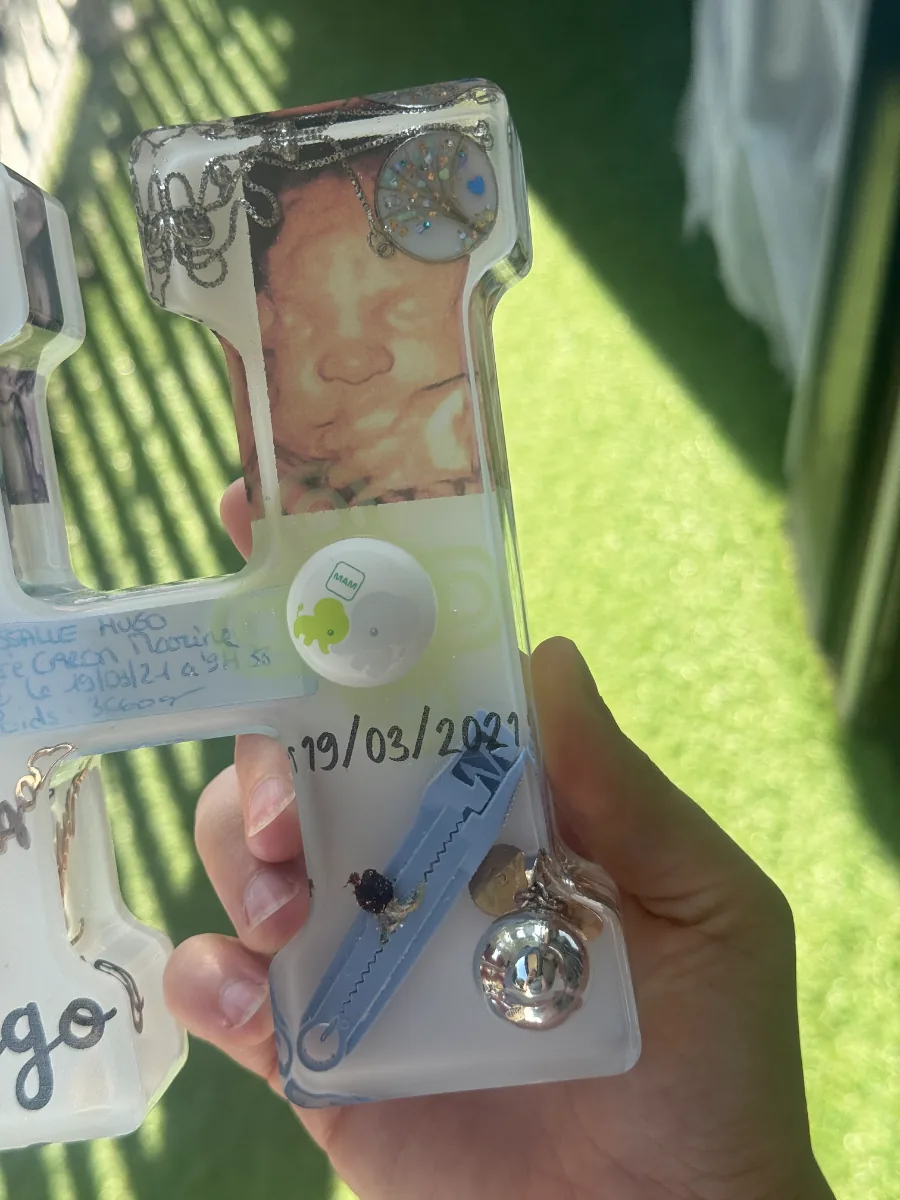 Lettre H de naissance en résine avec souvenirs de bébé, vue de biais
