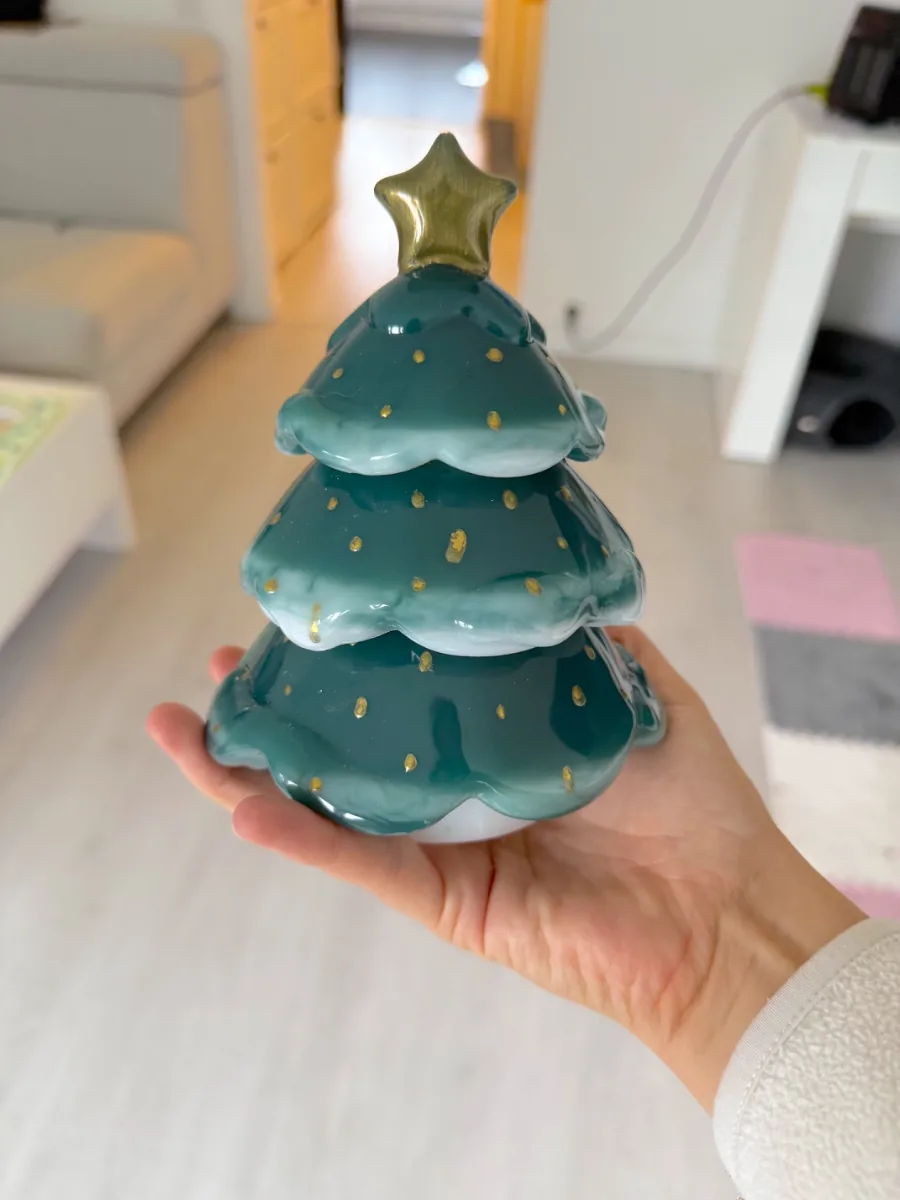 Sapin de Noël vert en céramique tenu dans la main
