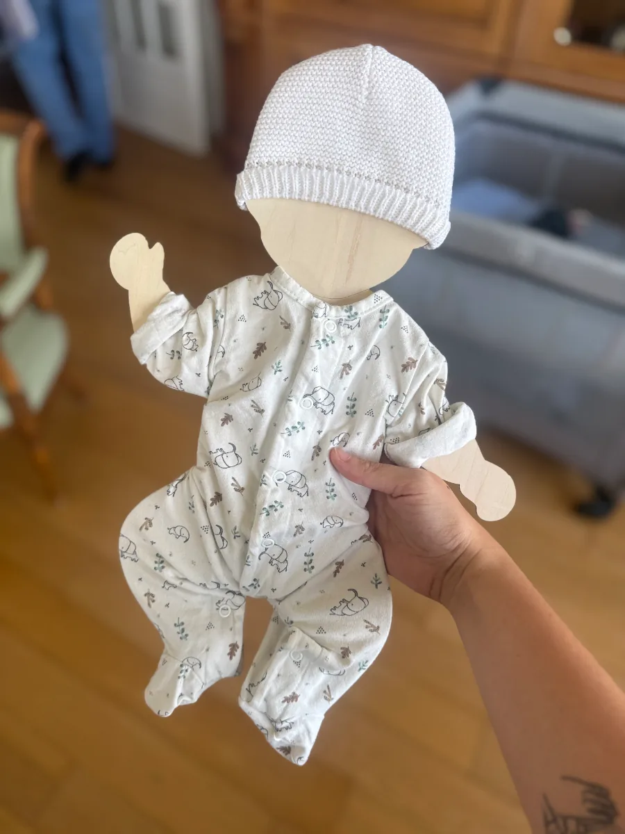 Silhouette de bébé en bois portant le premier pyjama et le bonnet de naissance