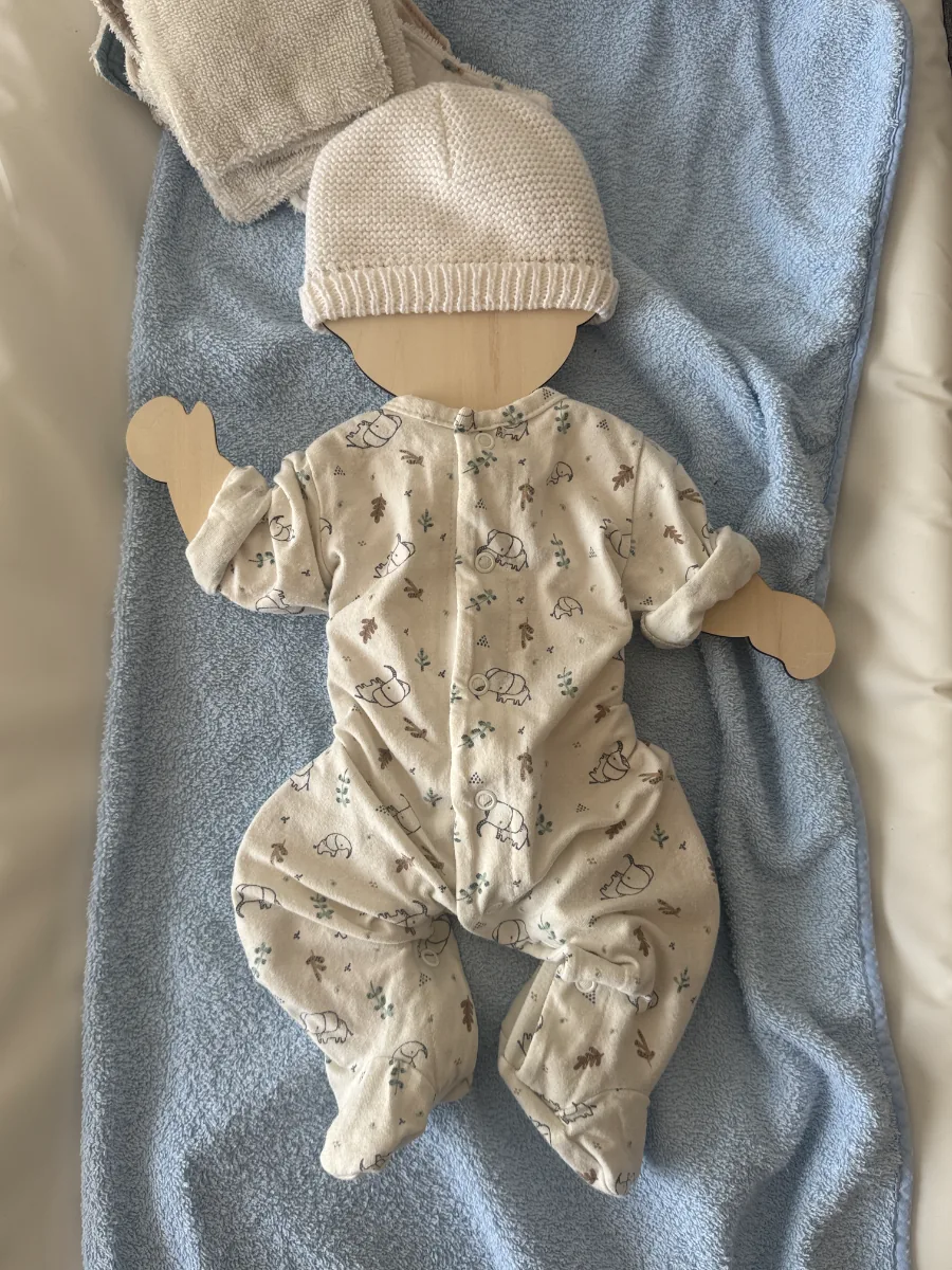 Support souvenir des vêtements de naissance posé sur une couverture bleue