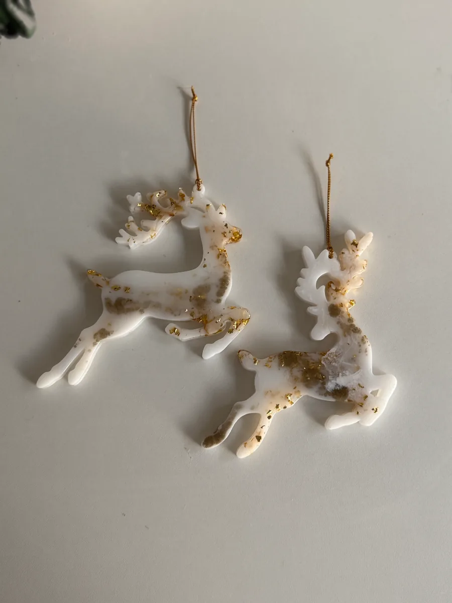 Deux cerfs de Noël en résine blanche et dorée
