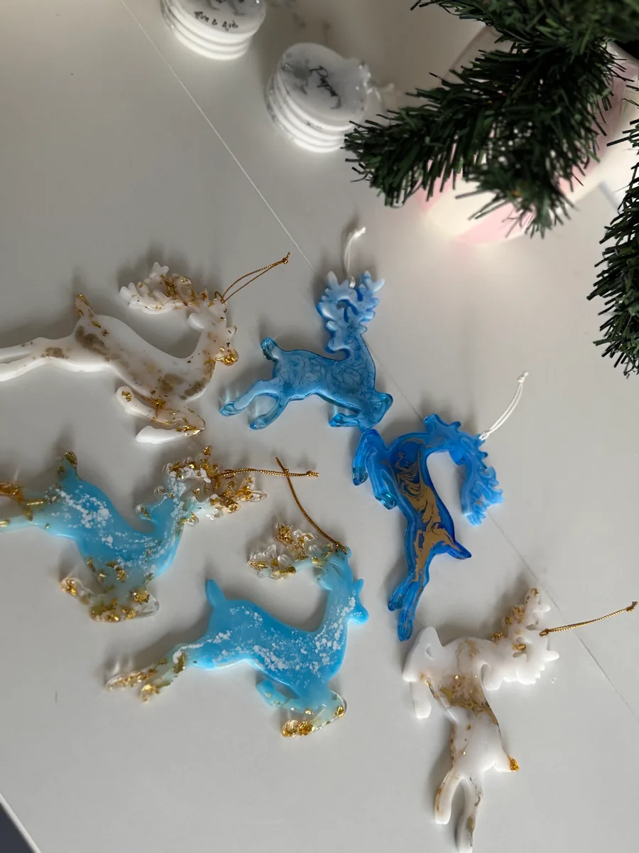 Cerfs de Noël en résine bleus et blancs dorés posés près d'un sapin