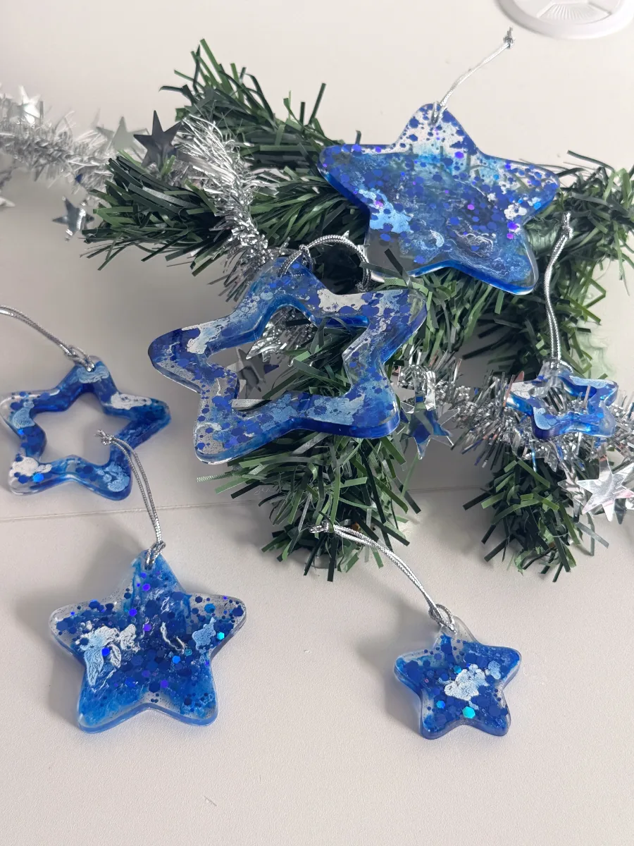 Suspensions étoile de Noël transparent et bleu roi sur des branches de sapin