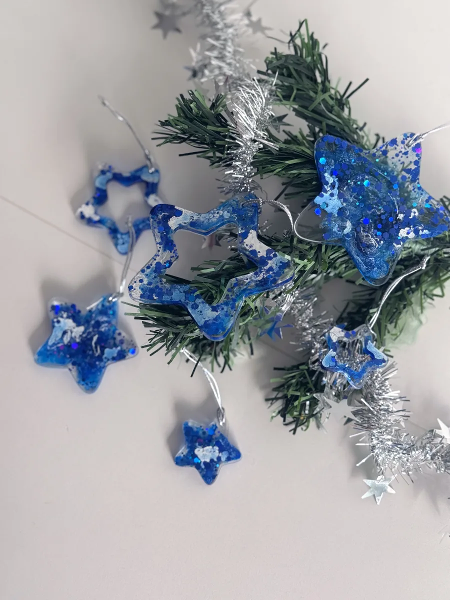 Étoiles de Noël bleu roi pailletées posées sur une guirlande argentée