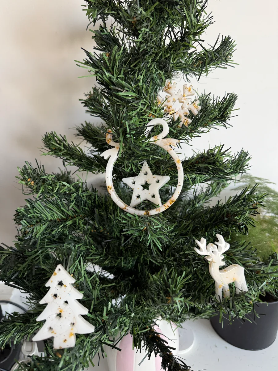 Sapin de Noël décoré de suspensions blanches : étoile, sapin et cerf