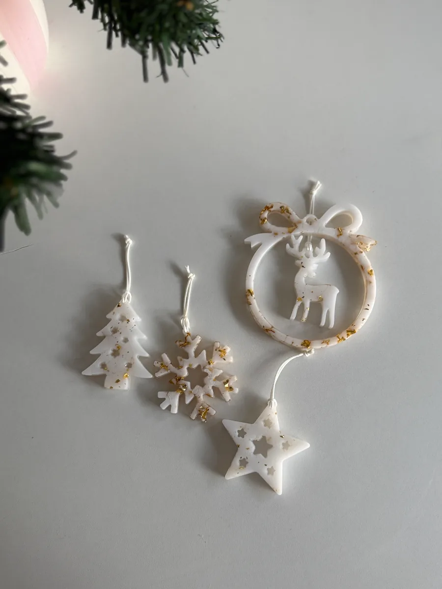 Suspensions de Noël blanches et dorées posées sur fond clair