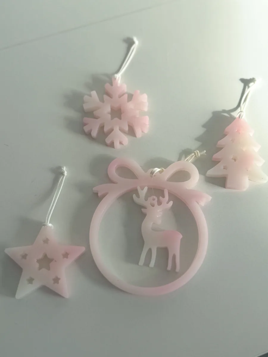 Suspensions de Noël en résine rose : flocon, étoile, sapin et cerf dans une boule à nœud